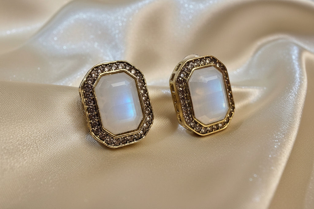 Decorative earrings with gemstone-like design on a satin surface