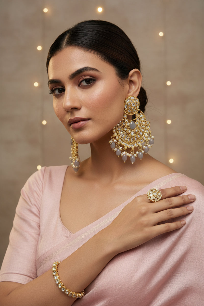 Ornate gold and crystal earrings on a satin surface